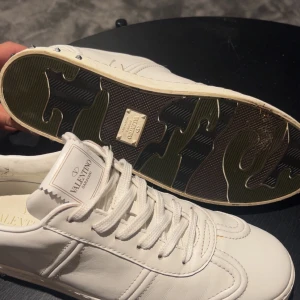 Valentino Garavani flycrew vita sneakers med nitar - Snygga vita sneakers från Valentino Garavani. Storlek 39!! Box och dustbax ingår! Tar byten!! Skriv om frågor eller mer bilder.