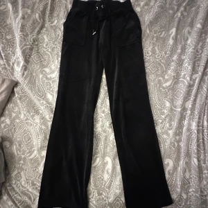 Svarta byxor Juicy Couture XS - Svarta mjukisbyxor från Juicy Couture dem är lågmidjade och dem är i bra skick det ända är att ena detaljen på ena snöret har gått av men dem är snygga ändå passa på och köp