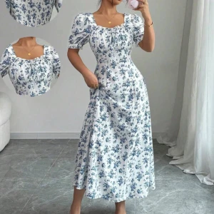 Vit långklänning med blå blommor - Superfin långklänning i vit med blått blommigt mönster och puffiga kortärmar. 