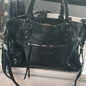Balenciaga liknande handväska - Påminner om balenciaga city bagen, aldrig använd. Köpt på en marknad i Spanien, men har somsagt tyvärr inte blivit använd. Passar till skolan/jobba då de får plats en del. Skriv om du undrar något!🩷