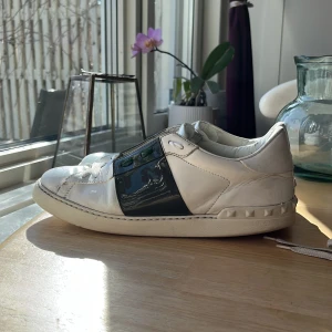 Valentino opens - Snygga Valentino open sneakers med grön glansig rand. Skorna är självklart äkta och og snören tillkommer. skicket på skorna får ni avgöra utifrån bilder och om ni vill ha några fler bilder är det bara att fråga. Jag tar gärna emot biten men kan även sälja skorna för ett bra pris vid intresse. Skorna är i storlek 42,5 men kan även passa 43 och 43,5 Har ni några som helst ytterligare frågor är det bara att slänga iväg ett meddelande så svarar jag ofta väldigt fort. Med vänliga hälsningar Oscar
