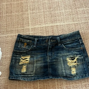 Jeanskjol från McQueen - Jag är inte hemma just nu utan kommer hem 5 april och kommer skicka varan då så skriv till mig innan ni köper ,Snygg jeanskjol från McQueen med slitna detaljer och en cool tvätt. Kjolen har fem fickor och knappstängning fram. Perfekt för en avslappnad stil. Det står att varan är i stolek S men skulle säga att det är liten i storleken mer som en xs 