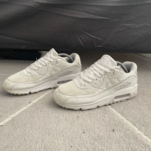 Vita Nike Air Max sneakers - Snygga vita Nike Air Max sneakers med klassisk design och synlig luftdämpning i sulan. Skorna har snörning och en stilren look som passar perfekt för en sportig stil.