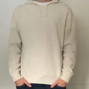 Vit kashmir hoodie från Sayless - Säljer en lyxig och mjuk vit hoodie från Sayless i kashmir. Perfekt för kyliga dagar med sin bekväma passform och stilrena design. Den har en klassisk huva med dragsko och långa ärmar. Storlek M passar även S