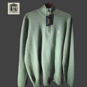 Grön tröja med dragkedja från Ralph Lauren - Säljer en stilren grön tröja från Ralph Lauren med dragkedja och broderad logga på bröstet. Perfekt för en avslappnad och snygg look. Tröjan är i nyskick, aldrig använd!!! Nypris på tröjan är 2395kr