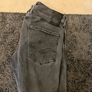 Replay Anbass Grå - Snygga grå jeansbyxor från Replay i modellen Anbass. W31 L32. Sitter större i storleken