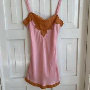 Rosa klänning - Säljer en söt rosa klänning med orangea spetsdetaljer vid halsringningen och fållen. Säljer eftersom jag inte använder längre 🩷🧡