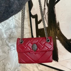 Röd quiltad axelväska från Kurt Geiger - Säljer en snygg röd axelväska från Kurt Geiger med quiltad design och kedjeaxelrem. Använd men bra skick 