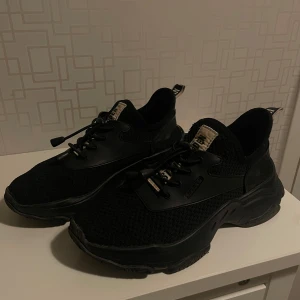 Svarta sneakers från Nike, Steve madden, Adidas,  - Snygga sneakers från olika märken med vit sula och klassisk logga på sidan. Skorna har snörning och är tillverkade i ett andningsbart material, perfekt för träning eller vardagsbruk. Pris går att diskutera!