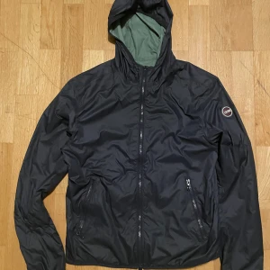 Colmar Windbreaker - En reversible colmar windbreaker som kan vara både mörkblå och olivgrön. Köpt på miinot för 1900kr och är knappt använd. Väldigt bra skicka, inga defekter. Väldigt skön jacka nu till våren! Passar för någon från 165-180 