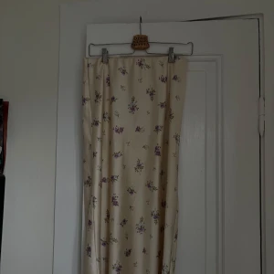 Blommig långkjol - En vacker långkjol med blommigt mönster i lila och beige. 