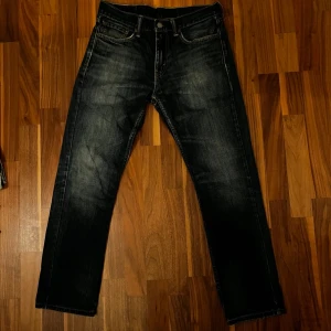 Levis 511  - Snygga Levis 511 jeans i mörkblå denim med klassisk femficksdesign. De har en slim passform och är perfekta för en stilren look. Midjan är w32 och längden l30. Perfekta för dig som gillar en tidlös stil. Lagning andra bilden 