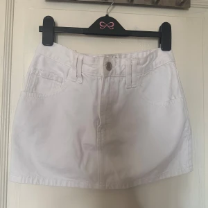 Vit jeanskjol - Säljer en  vit jeanskjol. Kjolen har knapp och dragkedja framtill och är i en kort modell. 