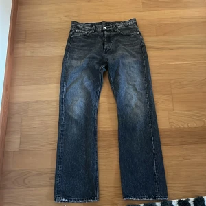 Mörkgrå jeansbyxor från HOPE - Säljer ett par mörkgråa jeansbyxor från HOPE i modellen Rush Jeans. Byxorna har en bootcutpassform med en washed design.