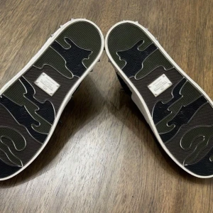 Valentino skor - Säljer ett par snygga Valentino sneakers i svart och vitt med glittriga partier och svarta skosnören. Skorna har vita detaljer och silverfärgade nitar på hälen där en fattas och därför är priset lägre. Medföljer box och dustbag o extra skosnören så givetvis äkta. Perfekta för dig som vill sticka ut lite extra!
