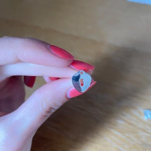 Silverfärgade örhängen med hjärtformad design - Säljer ett par små, hjärtformade örhängen i silverfärg. De har en minimalistisk design med ett utskuret nyckelhål i mitten. Perfekta för dig som gillar enkla men unika smycken.