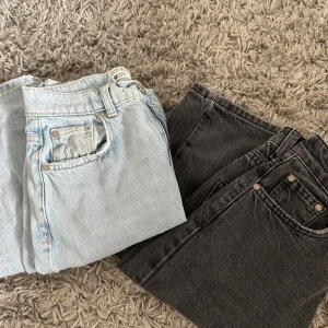 Två par jeans i ljusblått och svart - Säljer två par jeans, ett par ljusblåa med slitning och hål på knät samt ett par svarta. Båda har klassisk femficksdesign och raka ben. Perfekta för en avslappnad och trendig look.