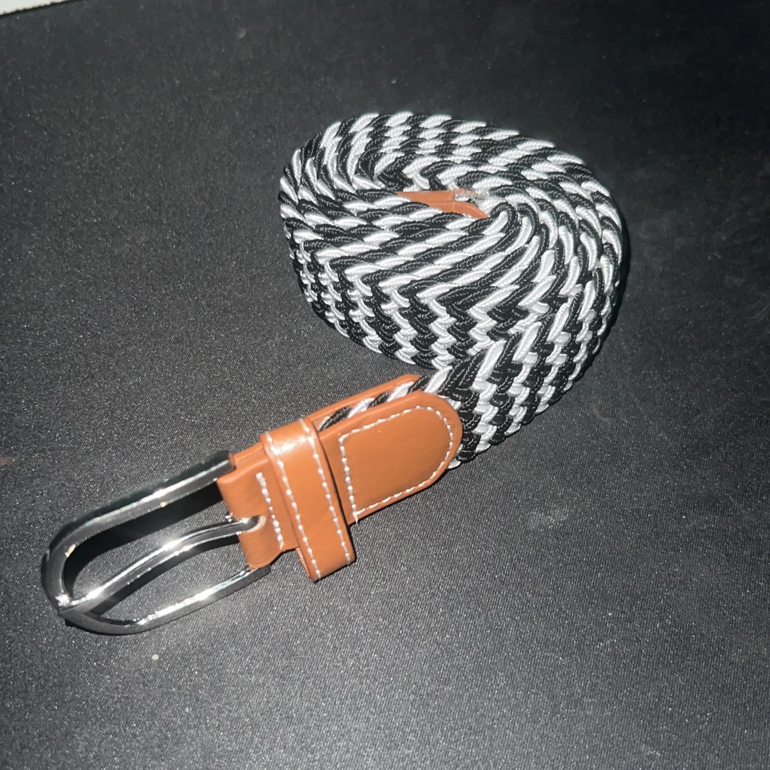 Svartvitt flätat bälte med bruna skinn-detaljer