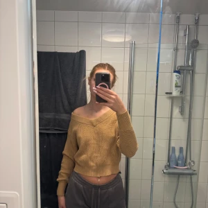 Beige stickad croppad tröja från Gina Tricot - Säljer en beige stickad tröja från Gina Tricot. Tröjan är croppad med lång ärm och har en snygg offshoulder-design. Perfekt för dig som gillar en avslappnad men trendig stil.