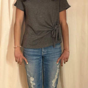 Mörkgrå knyt topp från Zara - Säljer en mörkgrå topp från Zara med korta ärmar och snygg knytdetalj i sidan. Perfekt till jeans eller kjol! Superfin. Pris kan diskuteras.😍