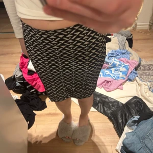 Svartvit mönstrad kjol från Gina Tricot - Säljer en svartvit kjol från Gina Tricot med grafiskt mönster. Kjolen är figurnära och har en kort längd, perfekt för dig som gillar en trendig och stilren look. Materialet är stretchigt och bekvämt.