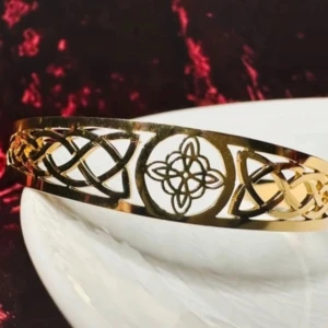 Keltiskt guldfärgat armband i rostfritt stål – justerbar och detaljerad design - Nytt - Wicca Witchy Andlig  - Helt nytt armband i rostfritt stål med guldfärgad finish och keltiskt knutmönster. Symbolisk design med känsla av andlighet och evighet. Lätt, bekvämt och justerbart tack vare öppen baksida. Ca 16 cm långt, 7 cm brett och 2 cm högt. Prutar ej – men bundlerabatt erbjuds vid köp av flera saker! ⸻