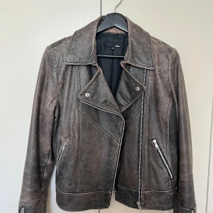 Skinnjacka H&M - Galet snygg vintagejacka i äkta skinn från H&M! Jackan har en tvättad svart/ brun look med snyggt slitet läder och silvriga dragkedjor. Tar emot att sälja men tyvärr för liten :(