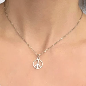 Peace Halsband Peacemärke silver imitation  - Fint halsband med en berlock i form av ett peace märke. Berlocken är ca 1,5 cm i diameter. Trädd på kedja i silverimitation som är justerbar 40-45 cm.  
