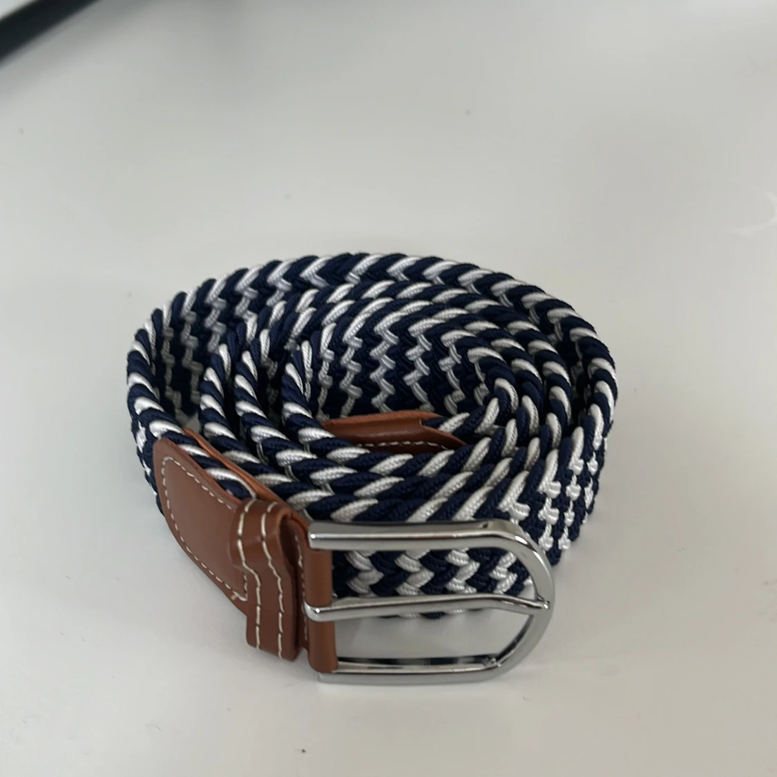 Blåvitt flätat bälte med läderdetaljer