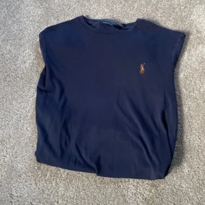 Mörkblå långärmad tröja från Polo Ralph Lauren perfekt till sommaren - Säljer en mörkblå långärmad tröja från Polo Ralph Lauren i modellen Custom Slim Fit. Tröjan har en liten broderad logga på bröstet.
