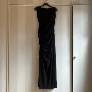 Svart långklänning med drapering - Prislappen finns kvar, aldrig använd. Nypris 399, följer för 160. Liten i storlek 