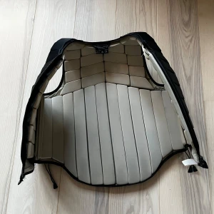 Racesafe ridväst - Stolek VUXEN L, det är fint skick på skyddsvästen och säljer den därav att jag råka köpa fel stolek av en tjej begagnat då jag trodde det var BARN L, på inn sidan av västen så på några ställen är det typ lite nopprigt, men det var så när jag fick den för det är alldeles för stor för mig så jag har inte använt den.