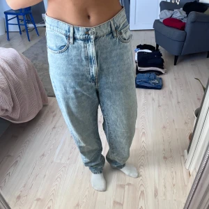 Ljusblå baggy jeans - Säljer ett par ljusblå baggy jeans med klassisk femficksdesign och hög midja. Jeansen har raka ben och stängs med dragkedja och knapp. 