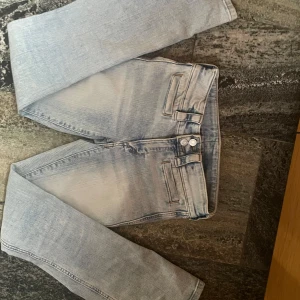 Ljusblå bootcut jeans från H&M - Säljer ett par ljusblå bootcut jeans från H&M med låg midja. Jeansen har två knappar framtill och inga fickor där bak. Säljer då de var för små för mig, helt oanvända från mitt håll men den förra säljaren hade använt de ett fåtal gånger