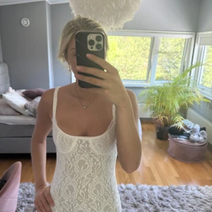 Vit spetsklänning från Pepparmayo - Supersnygg vit spetsklänning från Pepparmayo med figurnära passform och breda axelband. Klänningen har blommigt spetsmönster och en lätt v-ringad byst. Har prislapp kvar då jag beställde fel storlek. Perfekt för sommarens tillfällen!