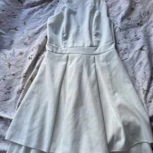 Vit kortklänning från WalG - Andvänd 1 gång.Supersöt vit klänning från WalG med markerad midja och utsvängd kjol. Klänningen är ärmlös och har en stilren design med dragkedja i ryggen. Perfekt för dig som vill ha en fräsch och enkel look med lite extra volym i kjolen.