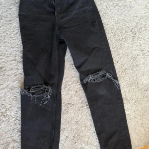 Jeans  - Raka jeans med slitningar över knäna 
