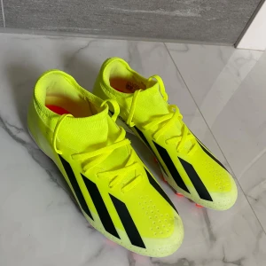 Adidas X Crazyfast MG fotbollsskor  - Adidas X Crazyfast fotbollsskor League MG. Skorna har inte kommit till användning då den kändes för liten. Skicket på skorna är nästan ny förutom några små mörka fläckar från konstgräs. Sko snörena är klippt till passande längd då nyköpt var för långa. Skorna har MG dobbar (multiground) så den funkar bra på de flesta planerna.