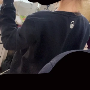 Mörkblå Sail Racing sweatshirt M - Mörkblå sweatshirt från Sail Racing i mjuk bomull. Tröjan har rund halsringning, långa ärmar och diskret logga på ryggen. Perfekt för dig som gillar stilren och sportig look. Passar dig som vill ha en enkel men snygg tröja till vardags.