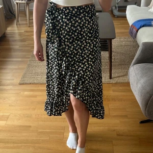 Blommig kjol med volang  - Använd några få gånger, som ny, normal i storleken. Kjolen knyts i midjan