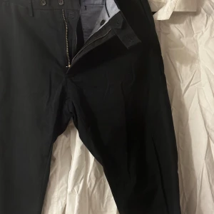 Vit skjorta från Polo Ralph Lauren och blå byxor från Polo Ralph Lauren  - Klassisk vit skjorta från Polo Ralph Lauren i slim fit-modell. Skjortan har knappar framtill och en stilren krage. Perfekt för dig som gillar en tidlös och clean look. Broderad logga på bröstet.