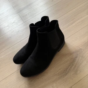 Låga boots  - Säljer ett par klassiska svarta chelsea boots från Graceland. Skorna har elastiska paneler på sidorna och en låg platt sula. Perfekta till både jeans och klänning för en stilren look. Aldrig använt!! De har endast legat i min byrå! 