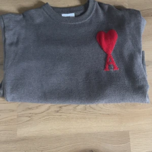 Grå stickad tröja från Ami Paris - Detta är en sparsamt använd lyxig Ami Paris tröja för lite finare tillfällen eller bara för vardag! 😍 Skick 7,5/10, finns en defekt som ni ser på sista bilden men det är endast nopprigt, inga hål eller fläckar. Storlek S