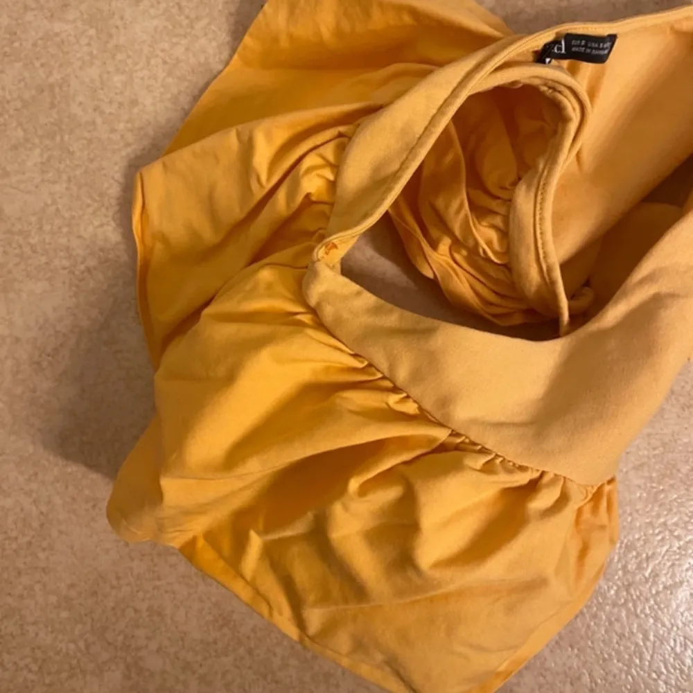 Säljer en snygg orange oneshoulder topp med en unik design. Toppen har en smickrande passform och är perfekt för att sticka ut. Den är tillverkad i ett mjukt material som känns skönt mot huden. Perfekt för sommarens alla tillfällen! 🌞. Yläosat.