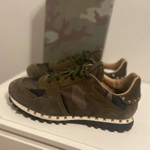 Valentino Rockrunner  - Snygga Valentino Rockrunner sneakers i en cool camouflage-design. Skorna har en kombination av mocka och syntetmaterial med nitar runt sulan för en edgy look. Perfekta för dig som vill sticka ut!. Storlek 44 samt priset är ej hugget i sten😝