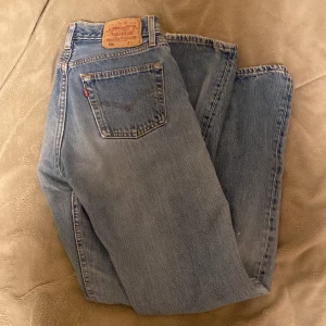 Levis 501 jeans i ljusblå denim - Klassiska Levis 501 jeans i ljusblå denim. De har en rak passform och knappgylf. Lite slitna vid inre låren (bild 4) men de är inget som syns, Levis märket över bakfickan är också lite slitet 💖Storlek står inte men skulle säga 36-38, lite stora för mig som är 34.