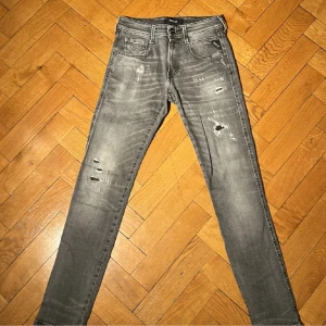 Grå jeans från Replay - Snygga grå jeans från Replay i modellen Anbass. De har fina slitningar och är i slim fit storlek 29/32