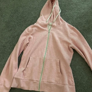 Rosa hoodie från Even&Odd - Mysig rosa hoodie från Even&Odd med dragkedja och huva. Perfekt för en avslappnad stil. Den har långa ärmar och praktiska fickor framtill.