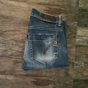 Dondup jeans - Säljer dessa snygga blåa dondup jeansen med slitningar. Modellen heter George. Storleken är 29. 9/10 skick, inga defekter alls. PRISET ÄR HUGGET I STEN. Hör av dig vid några funderingar!