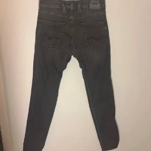 Grå Replay Anbass jeans - Hej säljer nu mina grå Replay Anbass jeans i slim fit. De har en klassisk femficksdesign med dragkedja och knapp. Perfekta för en stilren look med en modern touch. Bra skick inga defekter w33 L34 passar 175-185cm skulle jag säga